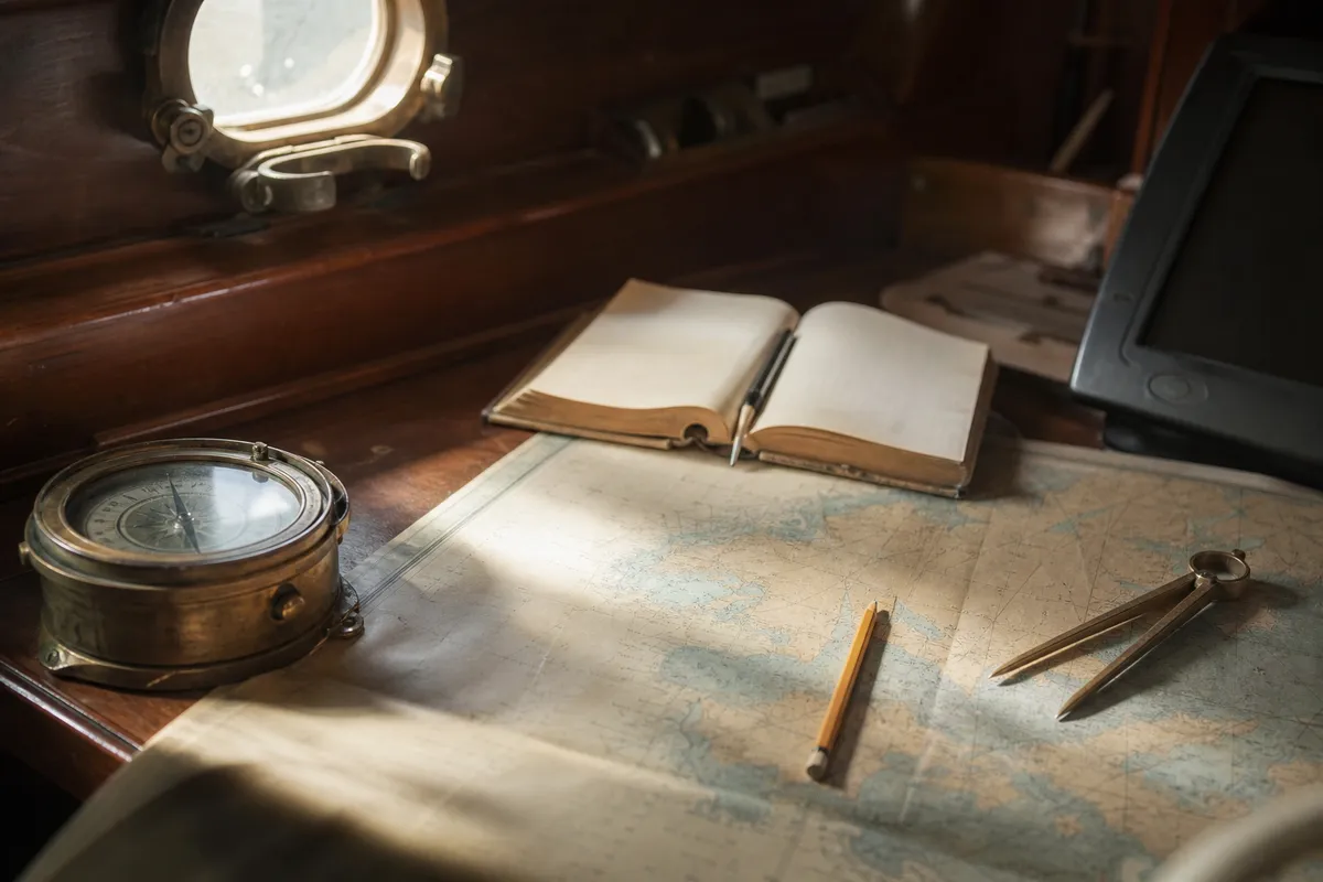 Kompass och sjökort på navigationsbord ombord på båt